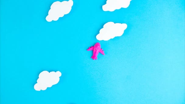 停止动作动画。粉红的小飞机在蓝天的云彩背景下飞行.飞机、旅行、空运、终端封锁和检疫概念 — 图库视频影像