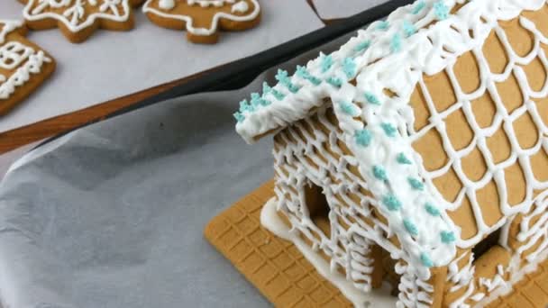 Beyaz krema ve mavi tozla süslenmiş, kar tanesi şeklinde zencefilli ekmek evi ve Noel kurabiyeleri, yeni yıl ve Noel tatilinden önce masada. — Stok video