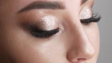 Şık bir akşamda güzel bir genç kız modelinin portresi dumanlı gözler kameraya bakar ve poz verir. Gözler yakın görünüm