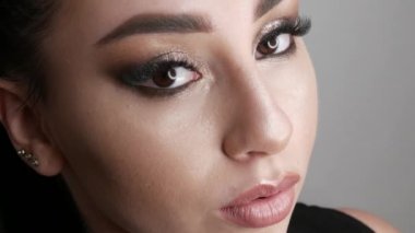 Şık bir akşamda güzel bir genç kız modelinin portresi dumanlı gözler kameraya bakar ve poz verir. Gözler yakın görünüm