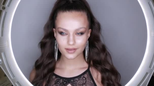 Magnifique modèle jeune fille avec une coiffure à queue de cheval haute touche cheveux et boucles d'oreilles massives en strass. Poser à haute couture avec soirée élégante maquiller les yeux fumés. Long cils extensions maquillage des yeux — Video