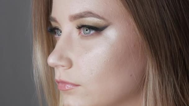 Портрет красивой молодой девушки модели в стильный вечер макияж дымчатые глаза смотрит на камеру и позируя лица вблизи вид — стоковое видео