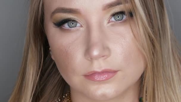 Портрет красивой молодой девушки модели в стильный вечер макияж дымчатые глаза смотрит на камеру и позируя лица вблизи вид — стоковое видео