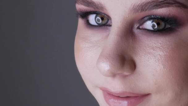 Όμορφη νεαρή κοπέλα μοντέλο με κομψό βραδινό μακιγιάζ smoky μάτια ποζάρουν και χαμογελαστά, υψηλή μόδα από κοντά — Αρχείο Βίντεο