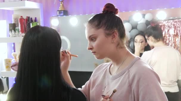 20 maart 2021 - Kamenskoe, Oekraïne: Meisjes make-up artiesten maken model make-up in schoonheidsstudio — Stockvideo