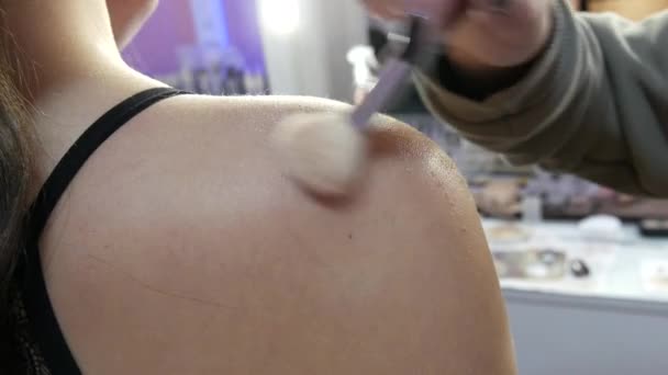 De borstel brengt speciale glitter aan op de huid van de modellen schouders — Stockvideo
