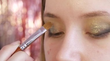 Güzeller güzeli altın rengi gölgeler güzellik salonundaki modelin gözlerine uygulanır.