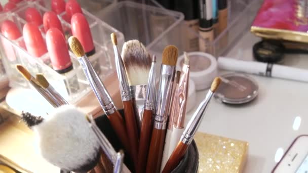 Various makeup brushes in a special glass on the table in a beauty salon — Stock Video