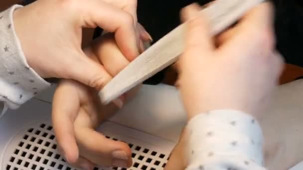 A manicura arquiva a forma das unhas com um arquivo especial de unhas. Ferramentas especiais de manicure polonês em unhas em casa vista de perto — Vídeo de Stock