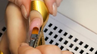 Tırnağa özel bir akrilik doku uygulanır ve özel bir kalıptaki tırnağın şeklini düzeltir. Tırnak uzatma servisi. Manikürcü, manikür jölesi tırnak uzatma görüntüsü yapıyor.