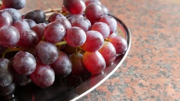 Bando de uvas rosa maduras na mesa da cozinha em casa — Vídeo de Stock