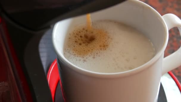Kapsül kahve makinesi ya da kahve makinesi sabah kahvesi yapar ve bir fincana süt döker. Evde kahve yapma ve dökme süreci — Stok video
