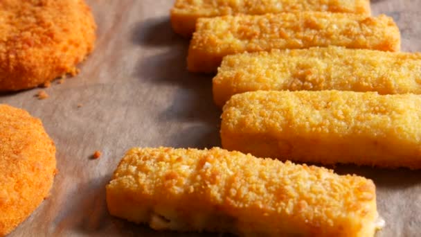 Queijo de camembert em massa em um alpendre com uma assadeira ao lado de palitos de peixe em massa. Preparação rápida de alimentos — Vídeo de Stock