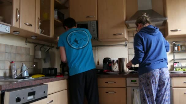 17 april 2021 - Kehl, Duitsland: Een pasgetrouwd stel dat samen een maaltijd bereidt in de keuken. Jongeman en vrouw koken eten, uitzicht van achteren — Stockvideo