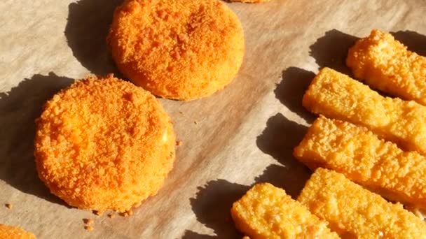 Camembert kaas in beslag op een veranda met een bakplaat naast vissticks in beslag. Fastfood bereiding — Stockvideo