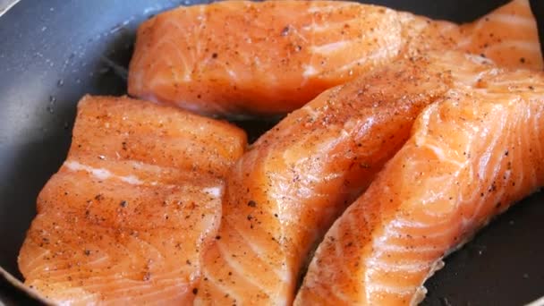 Duże kawałki filetów rybnych z łososia są smażone na patelni — Wideo stockowe