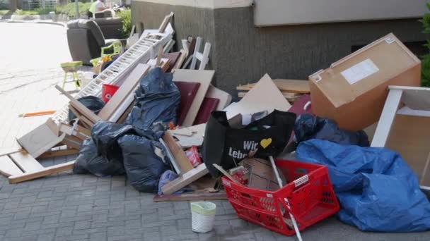 April 27, 2021 - Kehl, Germany: Large heaps of household rubbish, furniture, belongings, household items lie on street before it is removed by garbage truck. Once a year, people throw unwanted items — Stock Video