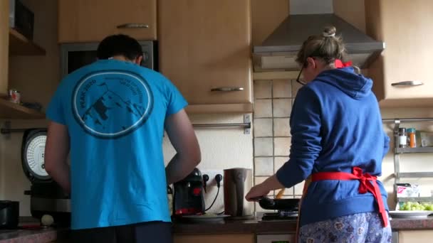17. April 2021 - Kehl, Deutschland: Ein frisch vermähltes Paar bereitet gemeinsam in der Küche ein Essen zu. Junger Mann und Frau beim Kochen, Blick von hinten — Stockvideo