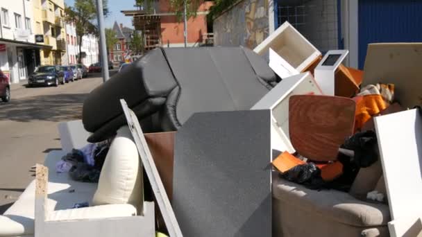 27 апреля 2021 года - Кель, Германия: Большие груды бытового мусора, мебели, вещей, предметов домашнего обихода лежат на улице, прежде чем их вывозят мусоровозом. Раз в год люди бросают ненужные вещи — стоковое видео