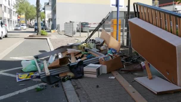 April 27, 2021 - Kehl, Germany: Large heaps of household rubbish, furniture, belongings, household items lie on street before it is removed by garbage truck. Once a year, people throw unwanted items — Stock Video