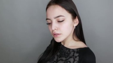 Salonda poz veren, kameranın önünde gülümseyen ve sevinen genç, güzel, sağlıklı kız modeli. Makyajsız yüz, makyaj yapmadan önce uzun kirpik uzantıları ile