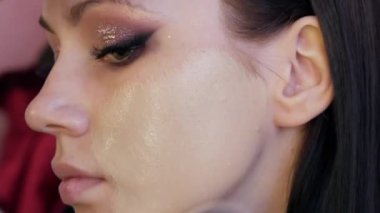 Makyaj stüdyosunda büyük bir makyaj fırçası, modellerin yüzüne parlak, güzel bir akşam makyajı ile temel alınır.