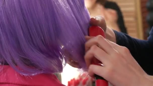 Fialová šeříková krátká paruka pod bob, kterou česají ruce kadeřnice maskérky — Stock video