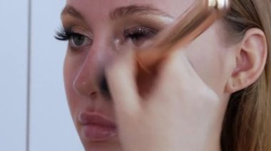 Özel bir makyaj fırçası cilt rengini yumuşatmak için modellere bir temel ya da kapatıcı uygular. Profesyonel makyaj.