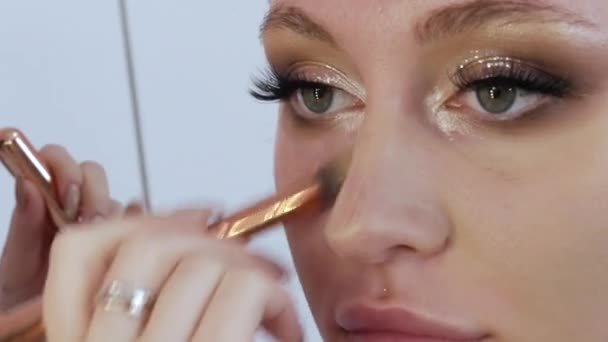 Een speciale make-up borstel brengt een laag foundation of concealer aan op het gezicht van de modellen om de huidtint te egaliseren. Beroepssamenstelling — Stockvideo