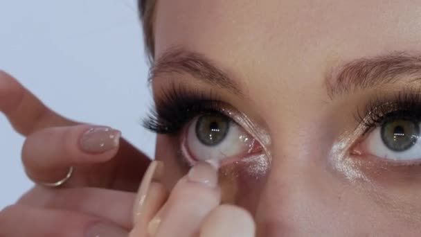 En vit penna drar linjen i det nedre ögonlocket slemhinnor för att betona uttrycksfullheten av modellerna ögon. Processen med ljusa kväll make-up närbild — Stockvideo