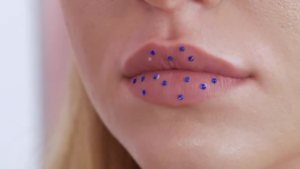 Professionelle Stylistin Make-up Artist macht helle Mode Make-up, klebt spezielle mehrfarbige Strass auf den Lippen — Stockvideo