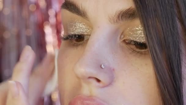 Modelo de niña con hermoso maquillaje brillante, de cuya cara se quita el brillo con una esponja de algodón — Vídeos de Stock