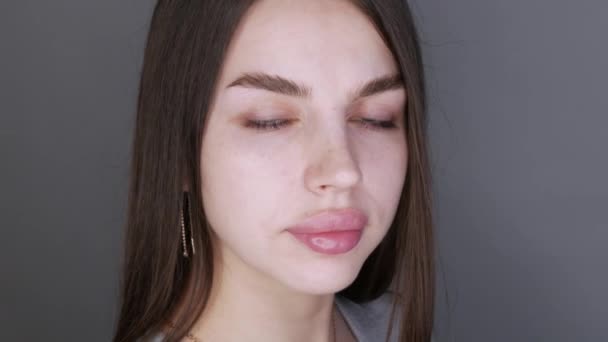 Jonge mooie vrouw model poseren voor de camera. Meisje met grote lippen en lange wimpers en bruine ogen zonder make-up — Stockvideo