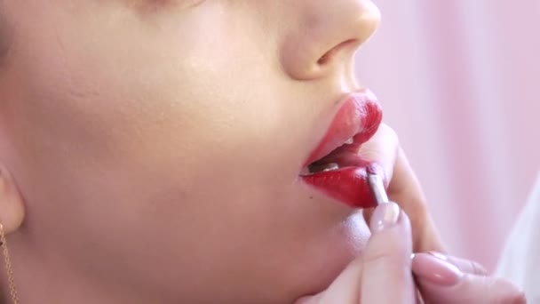 밝은 입술 화장 과커다란 아름다운 입술은 아름다운 미용실 에 특별 한 솔이 달린 빨간 립스틱 으로칠 해져 있다. 전문적 인 화장 — 비디오