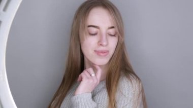 Makyajsız mavi gözlü genç kız kameraya poz veriyor.