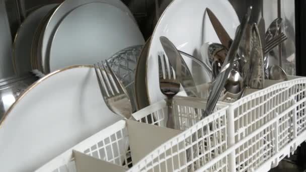 Чистий, свіжомитий посуд у посудомийній машині. Тарілки, горщики, ложки, виделки, келихи і чашки ідеально чисті — стокове відео