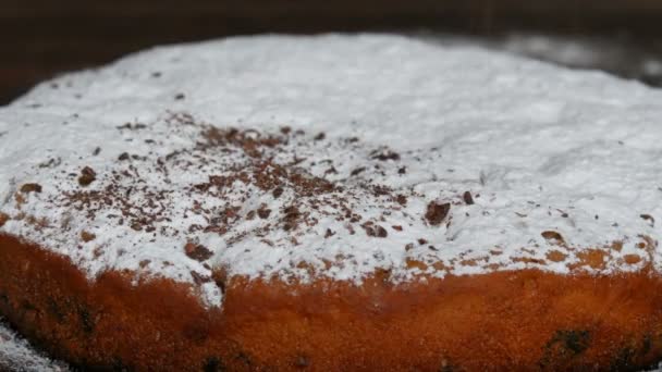 Hausgemachtes Backen. Köstliche und frisch gebackene Kirschtorte mit Puderzucker bestreut mit zerfetzten Schokoladenstücken — Stockvideo