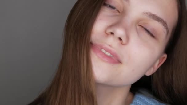 Ein schönes junges Mädchen mit blauen Augen im blauen Pullover posiert vor der Kamera. Model ohne Make-up mit natürlicher Schönheit — Stockvideo