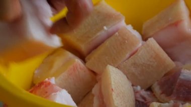 Kanlı ve kanlı büyük bir parça domuz bir erkek kasap tarafından parçalara ayrılır.