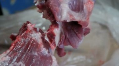 Kanlı ve kanlı büyük bir parça domuz bir erkek kasap tarafından parçalara ayrılır.