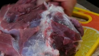 Kanlı ve kanlı büyük bir parça domuz bir erkek kasap tarafından parçalara ayrılır.