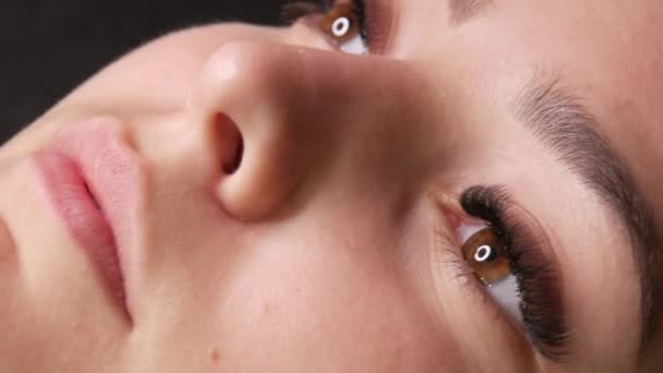 マイクロブレード、永久的なメイク眉タトゥーとうどんこ病を適用する前に美容室でソファに横たわっている若い女の子モデルの美しい顔。ビューを閉じる — ストック動画