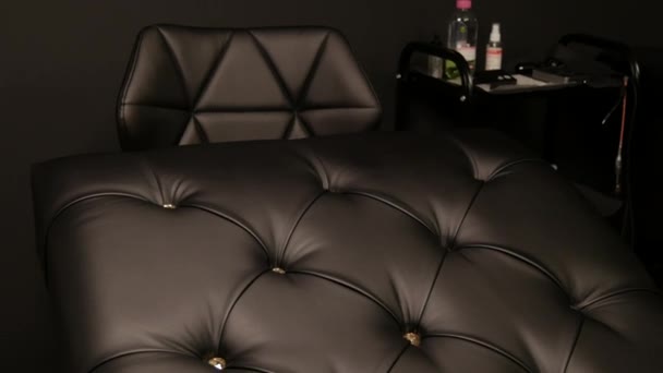 Gyönyörű fekete bőr kanapé kanapé az orvosok vagy kozmetikusok irodájában — Stock videók