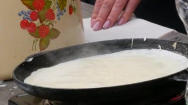 Hamurun gelecekteki krepler için kızartıldığı büyük bir gözleme tavası. Maslenitsa bayramı, Slavlar arasında bahar toplantısının hayati bir kutlaması, bir sokak yemeği festivali