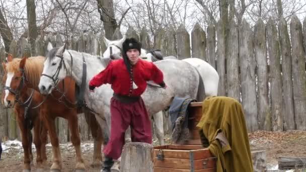 Zaporizhzhia, Ucrania - 13 de marzo de 2021: Actuación en el teatro cosaco con ropa popular ucraniana auténtica con canciones y trucos a caballo. Los hombres cosacos se divierten delante de la audiencia — Vídeos de Stock