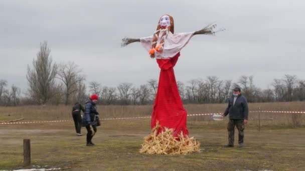 Zaporizhzhia, Ukrayna - 13 Mart 2021: Slav bayramı Maslenitsa. Pagan bebeği gri gökyüzüne karşı. Tatil için İdol. Krep Festivali. Rüzgar kurdeleleri savuruyor. Motanka bebeği yanmaya hazır. — Stok video