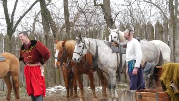 Zaporizhzhia, Ucrânia - 13 de março de 2021: apresentação de teatro cossaco com autênticas roupas folclóricas ucranianas com canções e truques a cavalo. Cossaco homens se divertindo na frente do público — Vídeo de Stock