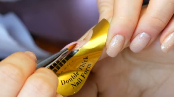 En speciell akrylkonsistens appliceras på nageln och korrigerar nagelns form på en speciell stencil. Nagelförlängningstjänst. Manicurist gör en manikyr Gel Nail förlängning närbild — Stockvideo