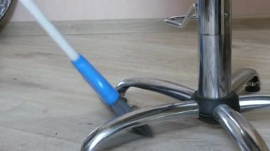 Süpürge ve kepçe bir berber dükkanında bir sürü insan saçını yerden temizler.