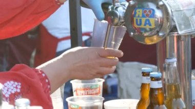 1 Haziran 2018 - Svidivok Köyü, Ukrayna Tarasova Dağ Moto Festivali, bir kadın eli plastik bardağa bira dolduruyor